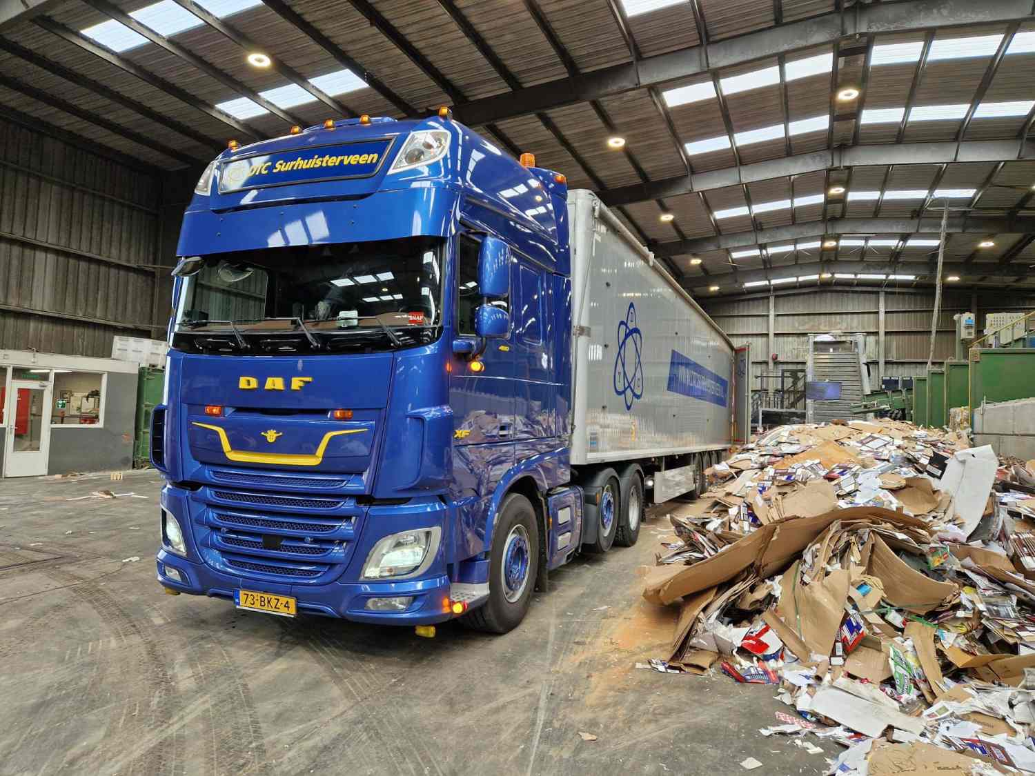 Walking floor trailer met losgestorte goederen in fabriekshal