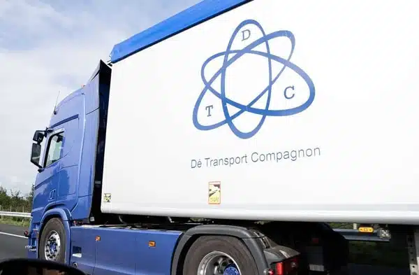 Zijaanzicht van DTC walking floor vrachtwagen rijdend op snelweg
