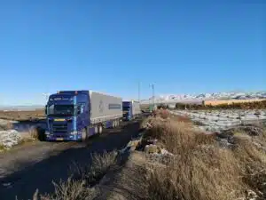 DTC Scania tautliner combinatie onderweg met internationaal transport door besneeuwd berglandschap voor De Transport Compagnon.
