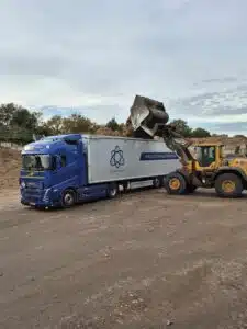 DTC Surhuisterveen Volvo schuifvloer trailer wordt geladen met biomassa door Volvo shovel op transportlocatie.