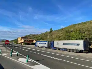 Twee DTC vrachtwagens langs de weg in Zuid-Europa tijdens internationaal transport vanuit Leeuwarden door Europa.