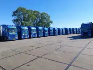 Wagenpark van transportbedrijf DTC in Leeuwarden met blauwe Scania en Volvo trucks klaar voor transport in Friesland.